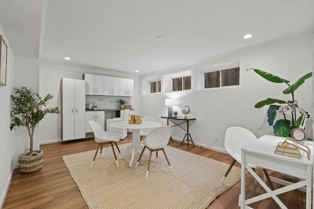 dining space featuring ornamental molding and hardwood / wood-style floors