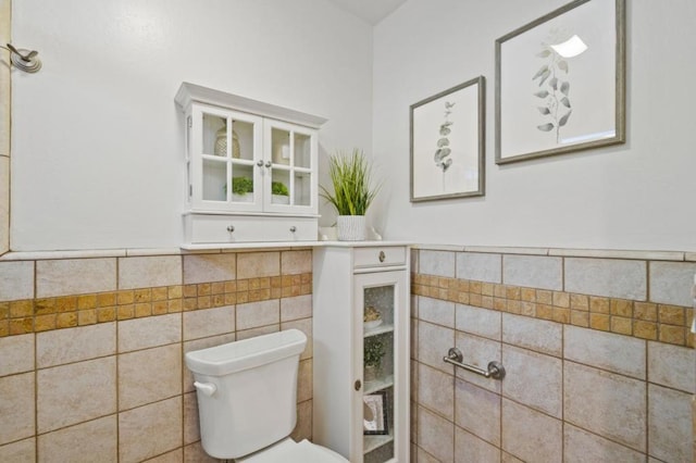 bathroom with toilet and tile walls