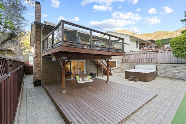 wooden terrace featuring a mountain view, a patio area, and a hot tub