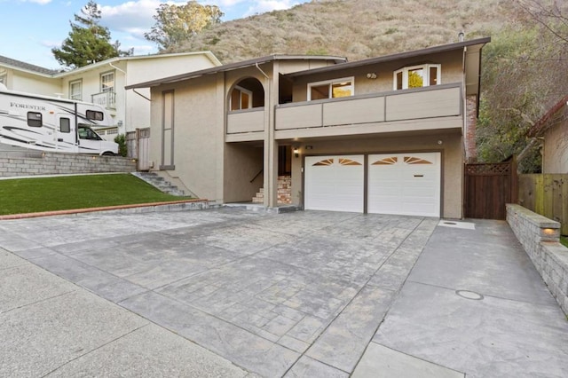 view of front of house featuring a balcony, a garage, and a mountain view