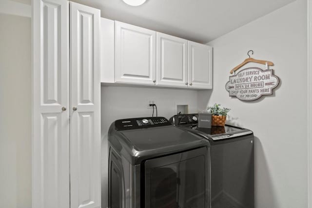 laundry area with washing machine and dryer and cabinets