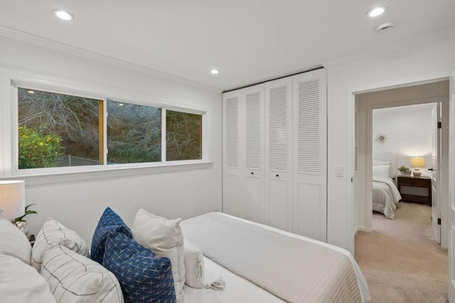 bedroom featuring light carpet, a closet, and crown molding