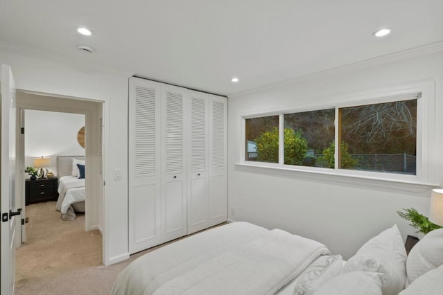 bedroom with light carpet, a closet, and ornamental molding