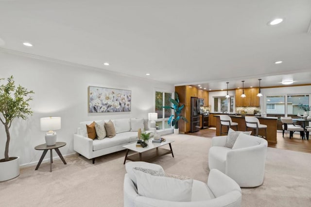 carpeted living room featuring crown molding and a healthy amount of sunlight