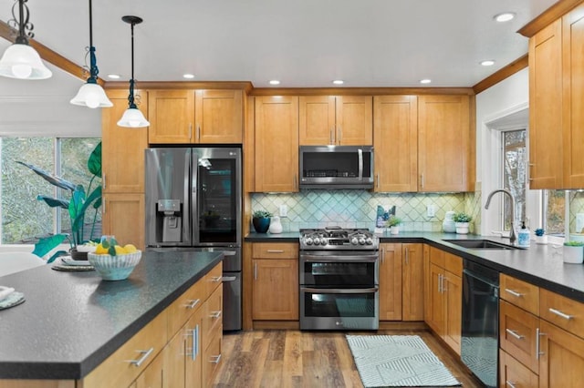 kitchen with pendant lighting, hardwood / wood-style floors, stainless steel appliances, decorative backsplash, and sink