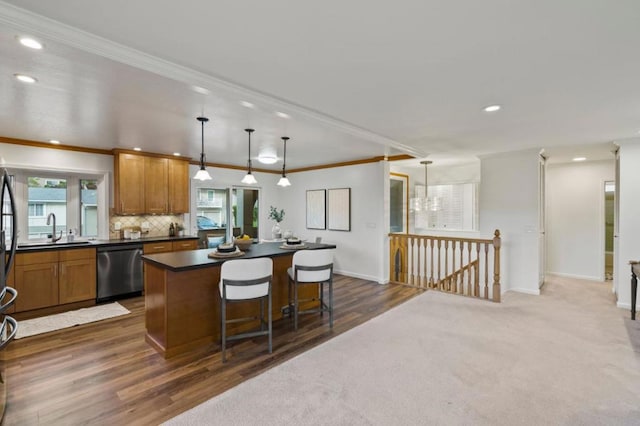 kitchen featuring stainless steel dishwasher, plenty of natural light, a breakfast bar, and decorative light fixtures