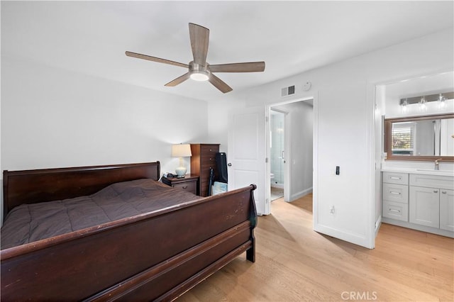 bedroom featuring ceiling fan, sink, light hardwood / wood-style flooring, and ensuite bath