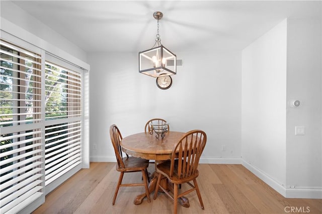 dining room featuring light hardwood / wood-style flooring and an inviting chandelier