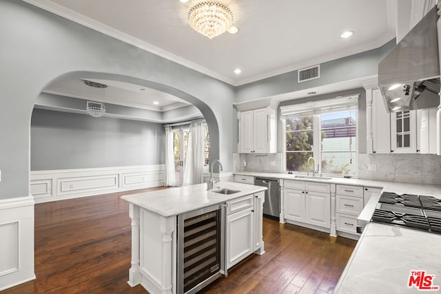 kitchen featuring exhaust hood, dishwasher, sink, white cabinetry, and beverage cooler