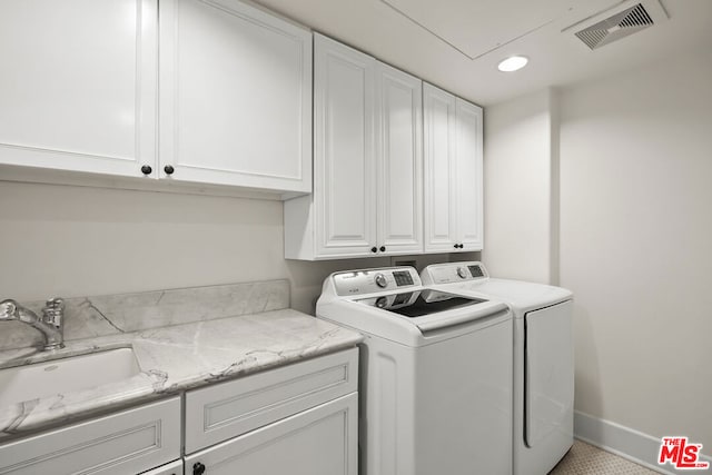 washroom featuring cabinets, sink, and independent washer and dryer