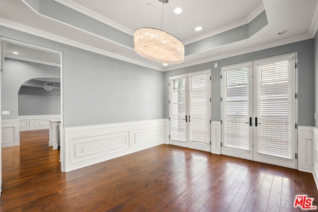 unfurnished room featuring french doors, dark hardwood / wood-style floors, ornamental molding, a notable chandelier, and a tray ceiling