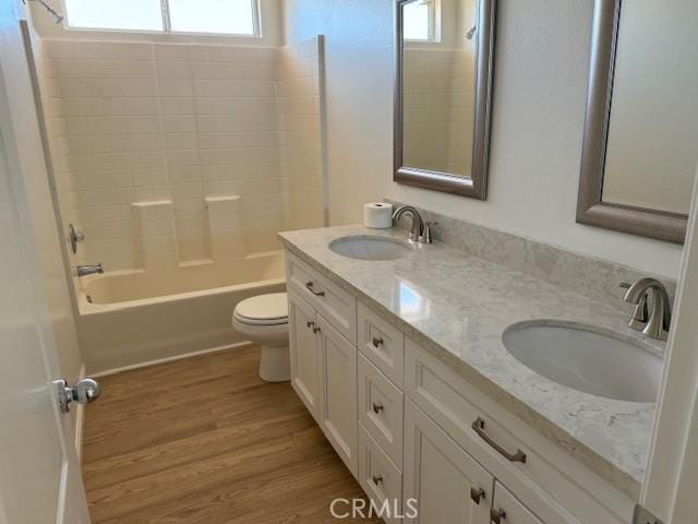 full bathroom featuring toilet, shower / tub combination, hardwood / wood-style flooring, and vanity