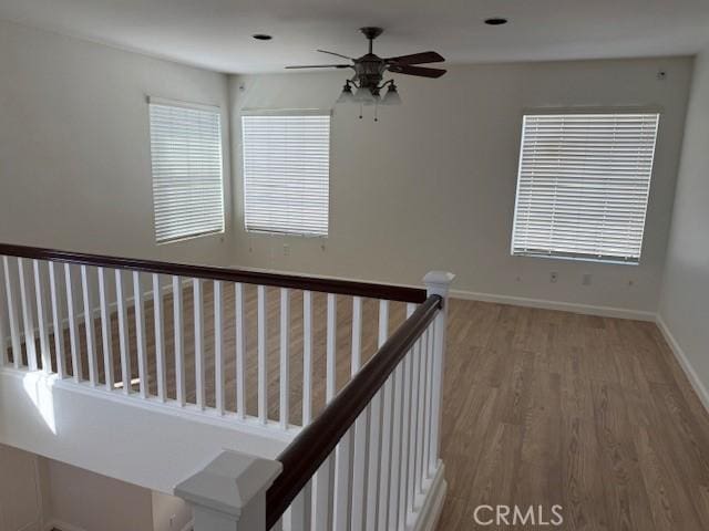 stairway featuring hardwood / wood-style flooring and ceiling fan