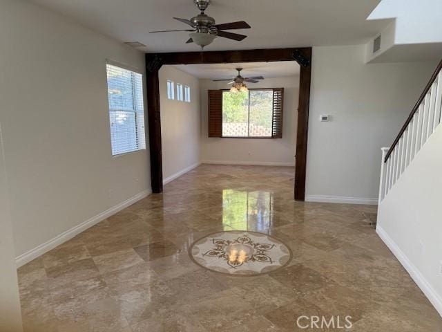 spare room with ceiling fan and beamed ceiling