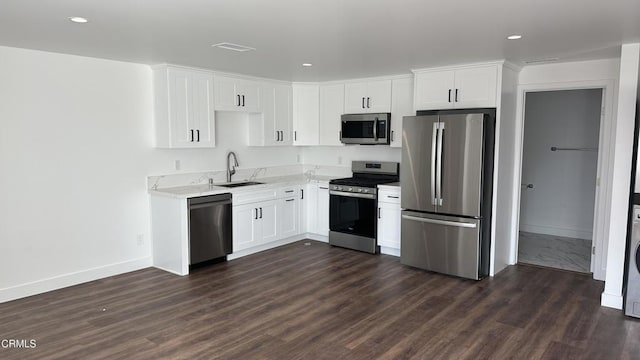 kitchen featuring white cabinetry, sink, dark hardwood / wood-style flooring, light stone counters, and stainless steel appliances