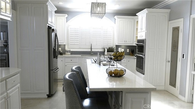 kitchen featuring an inviting chandelier, white cabinetry, an island with sink, appliances with stainless steel finishes, and sink