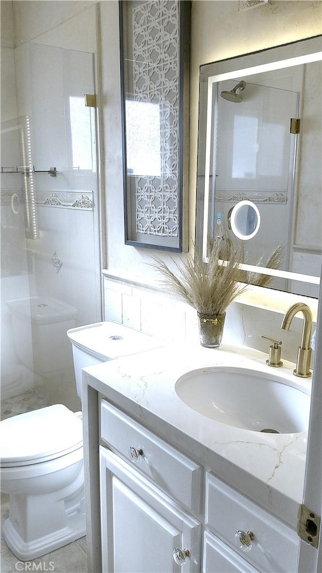 bathroom with toilet, vanity, and a shower