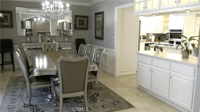 dining room featuring light tile patterned floors, ornamental molding, and a chandelier