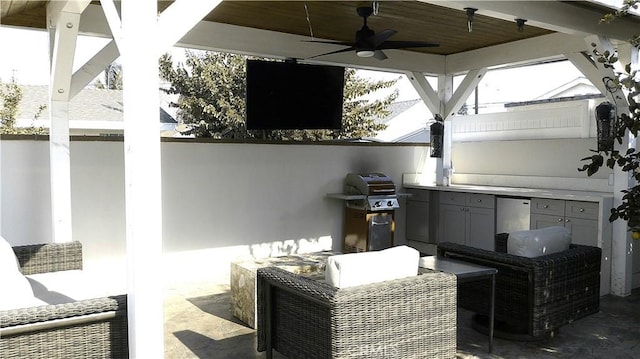 view of patio / terrace featuring ceiling fan, a grill, and an outdoor kitchen