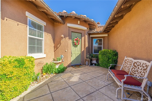 view of exterior entry with a patio