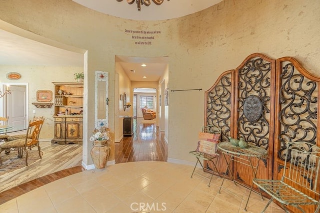 hallway featuring a chandelier and tile patterned floors