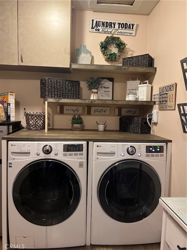 laundry room with independent washer and dryer and cabinets