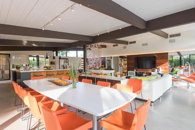 dining room with sink and beamed ceiling