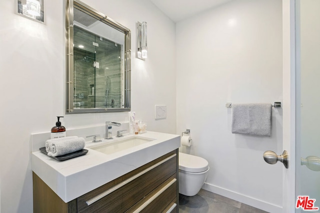 bathroom featuring toilet, vanity, and a shower with door