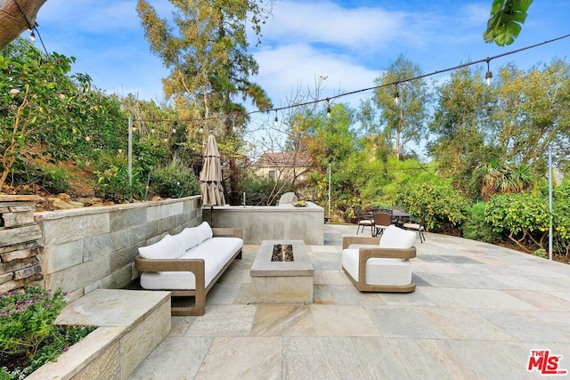 view of patio featuring an outdoor living space with a fire pit