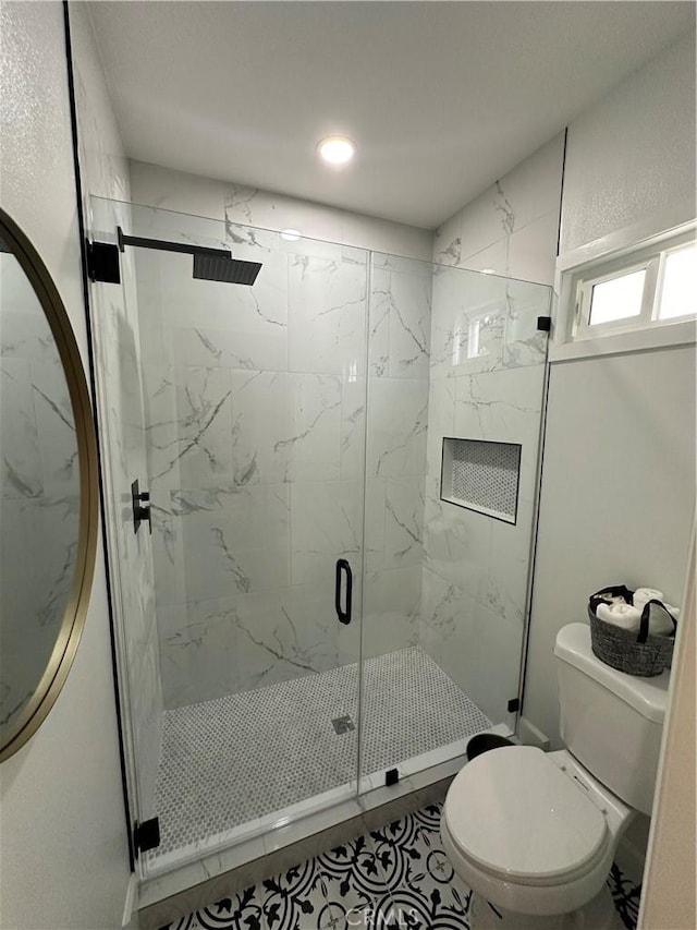 bathroom with a shower with shower door, tile patterned floors, and toilet