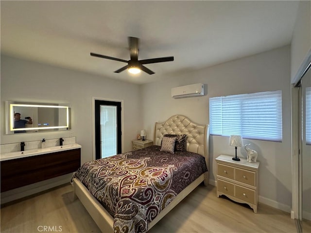 bedroom with light wood-type flooring, ceiling fan, and an AC wall unit