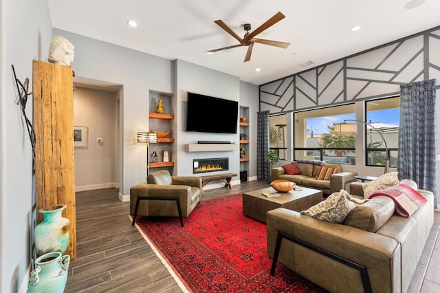 living room with ceiling fan and built in shelves