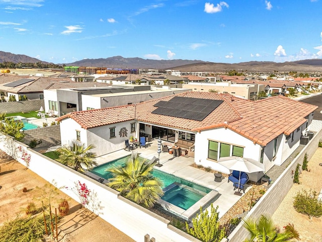 rear view of house with a mountain view and a patio