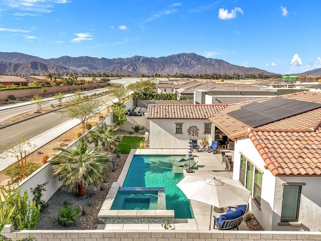 view of swimming pool with a mountain view, a patio, and an in ground hot tub