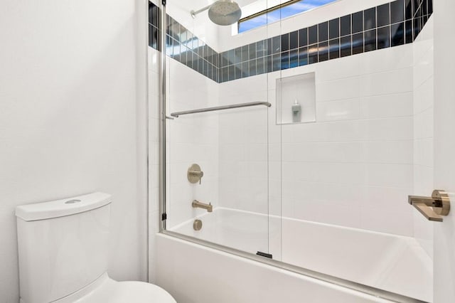 bathroom featuring bath / shower combo with glass door and toilet