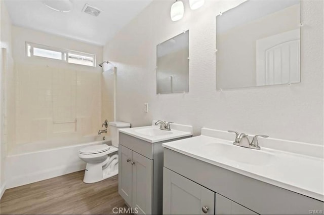 full bathroom featuring vanity, hardwood / wood-style flooring, shower / tub combination, and toilet