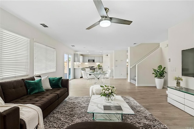 living room featuring light hardwood / wood-style floors and ceiling fan