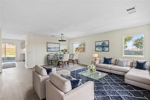 living room with an inviting chandelier and hardwood / wood-style flooring