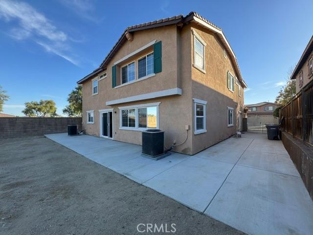 rear view of property with central AC and a patio