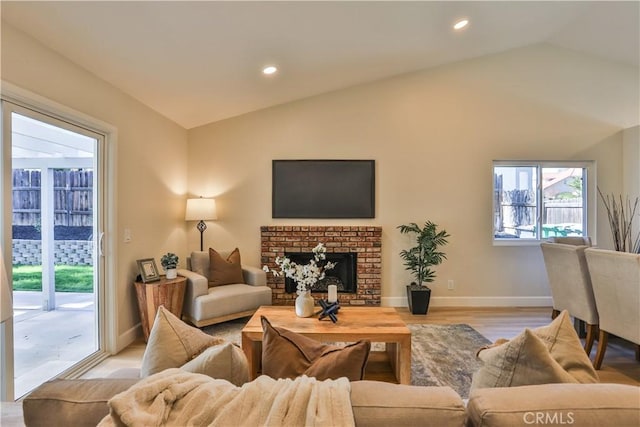 living room with light wood-type flooring, lofted ceiling, and a fireplace