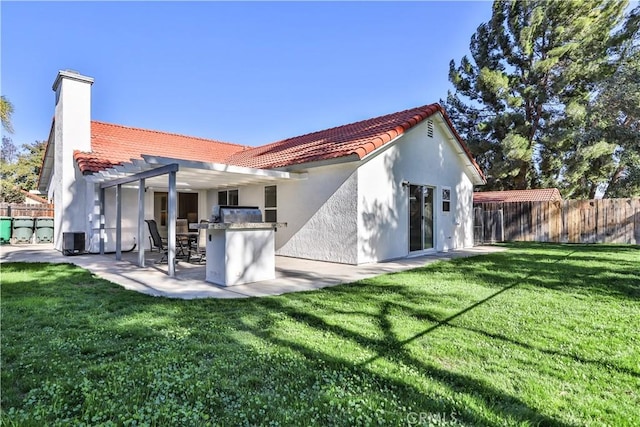 rear view of house featuring a lawn, exterior kitchen, a pergola, and a patio