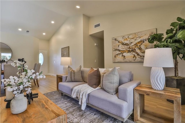 living room featuring hardwood / wood-style flooring and vaulted ceiling