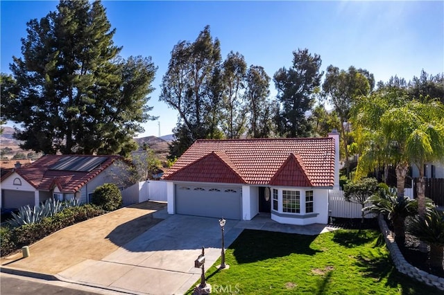 view of front of house featuring a front yard, a garage, and a mountain view