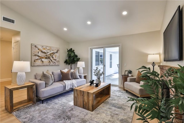 living room featuring lofted ceiling and hardwood / wood-style floors