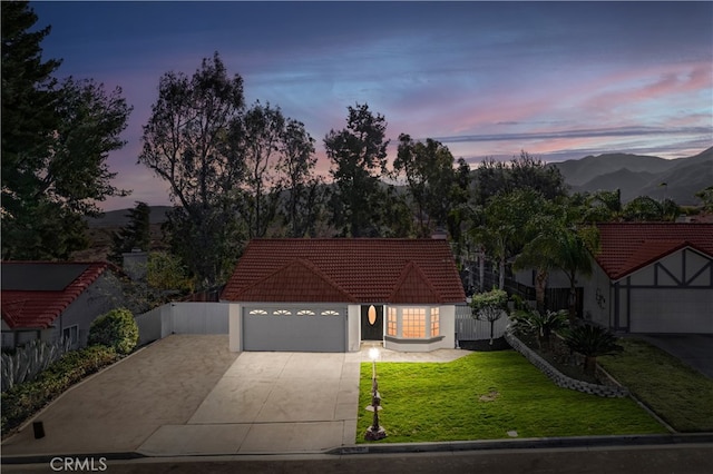 view of front of property featuring a mountain view, a yard, and a garage