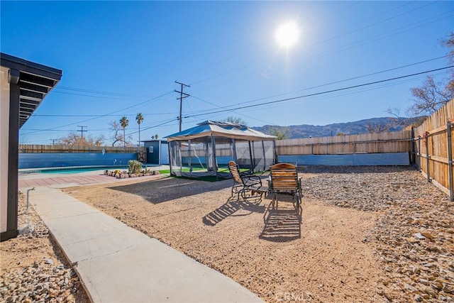 view of yard with a gazebo, a mountain view, and a fenced in pool