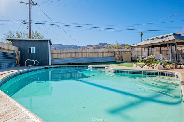 view of pool featuring a mountain view and a storage shed