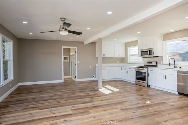 kitchen with light hardwood / wood-style floors, sink, white cabinetry, and stainless steel appliances