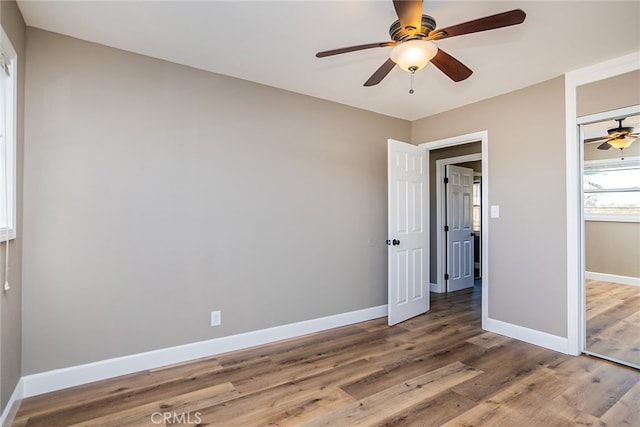 unfurnished bedroom featuring ceiling fan, a closet, and hardwood / wood-style floors