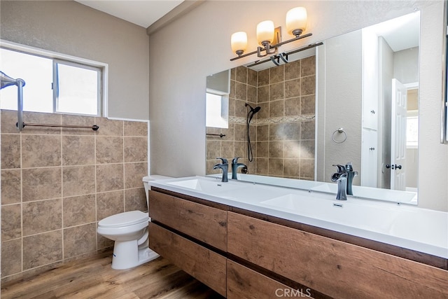 bathroom featuring hardwood / wood-style flooring, a wealth of natural light, toilet, and vanity